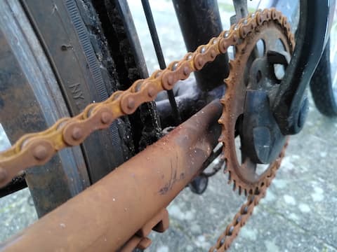 Nahaufnahme einer braunen, rostigen Fahrradkette, als Symbol für Vernachlässigung.