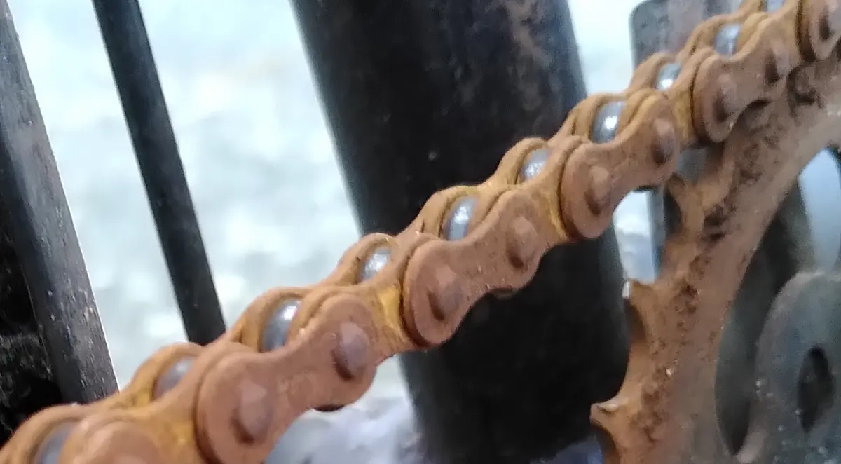 Nahaufnahme einer braunen, rostigen Fahrradkette, als Symbol für Vernachlässigung.